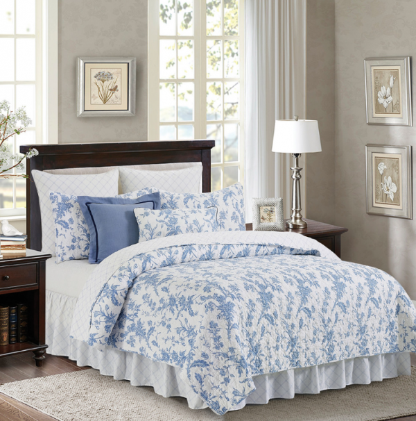 Ranjang dengan selimut dan bantal motif klasik